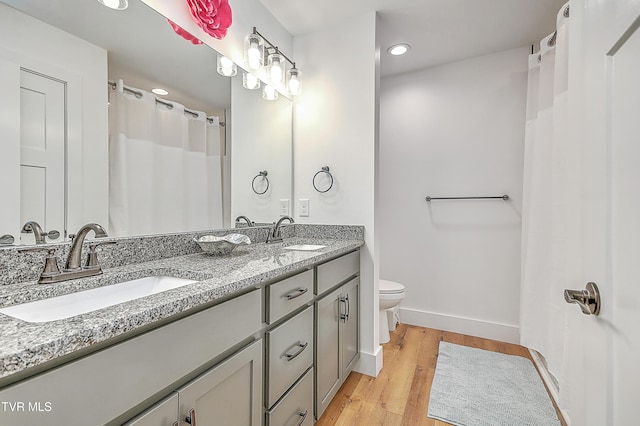 bathroom with hardwood / wood-style floors, vanity, and toilet