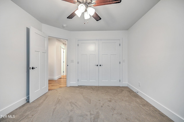 unfurnished bedroom with ceiling fan, a closet, and light carpet