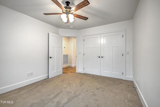 unfurnished bedroom featuring a closet, light colored carpet, and ceiling fan