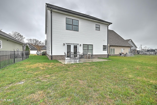 rear view of house featuring a lawn and a patio area