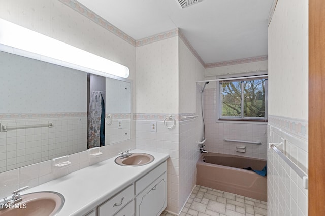 bathroom featuring vanity, shower / bath combination with curtain, and tile walls