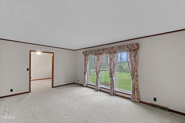 empty room with crown molding and light colored carpet