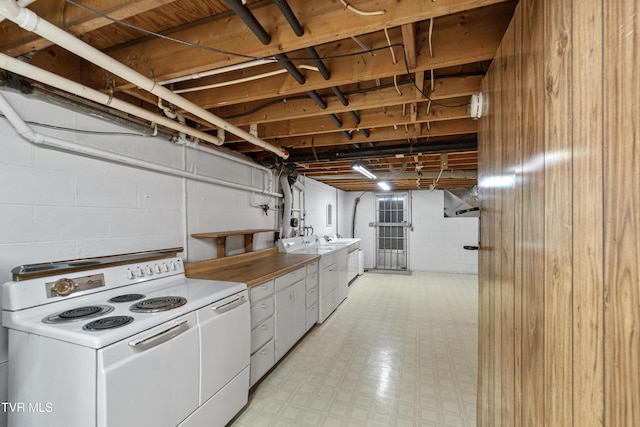 kitchen with white cabinets, washing machine and dryer, and electric stove