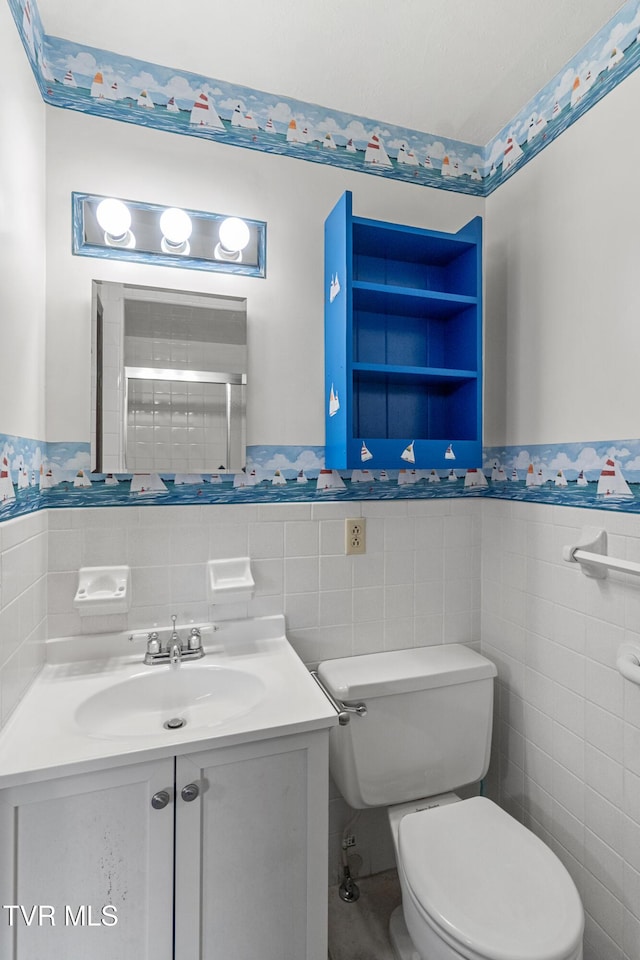 bathroom featuring vanity, toilet, and tile walls