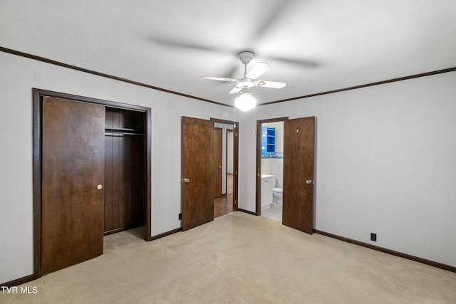 unfurnished bedroom with ceiling fan, crown molding, ensuite bathroom, light carpet, and a closet