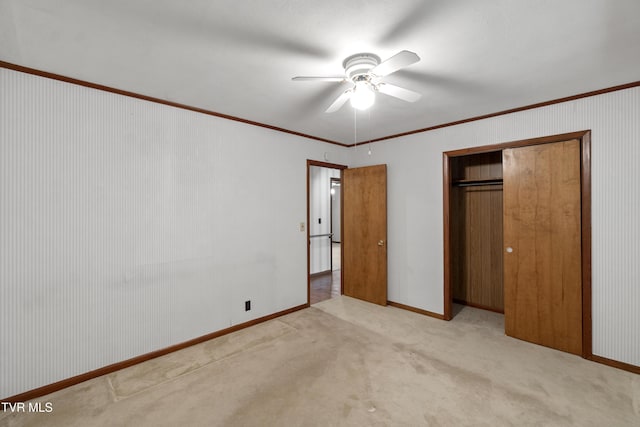 unfurnished bedroom with ceiling fan, light colored carpet, ornamental molding, and a closet