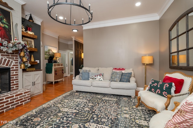 living room with a chandelier, hardwood / wood-style floors, a fireplace, and crown molding