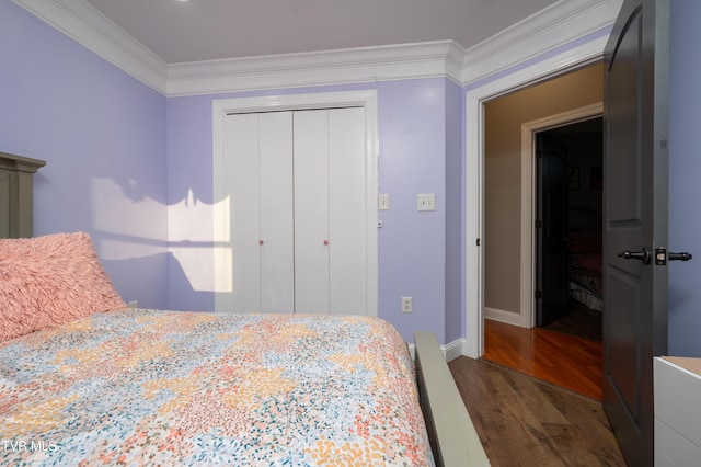 bedroom featuring dark hardwood / wood-style flooring, a closet, and crown molding