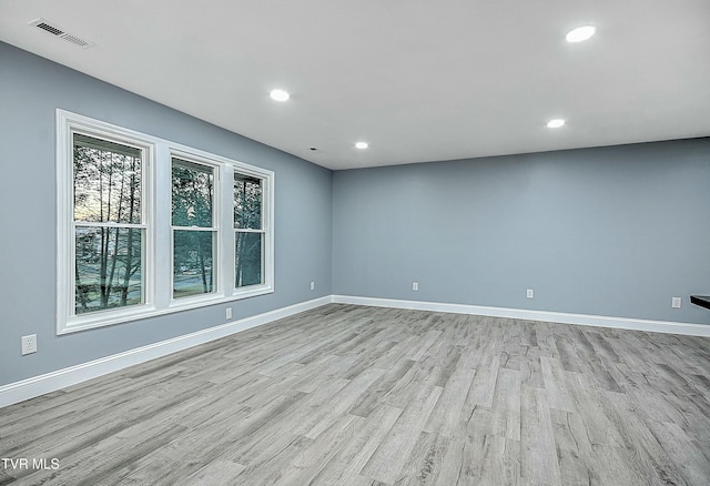 empty room with light wood finished floors, visible vents, recessed lighting, and baseboards