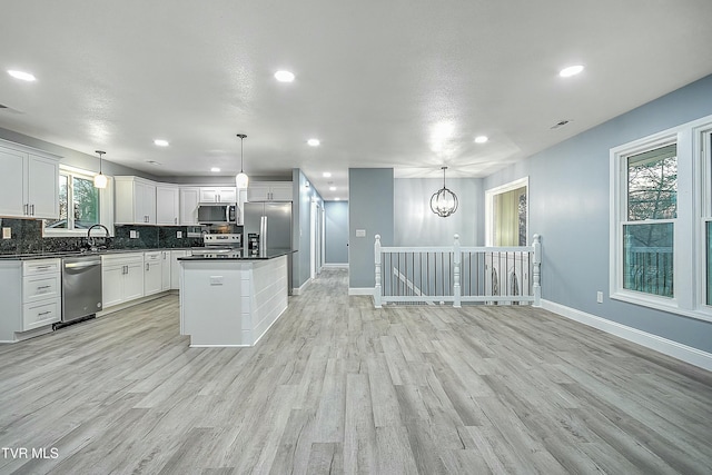 kitchen with a wealth of natural light, decorative backsplash, dark countertops, and appliances with stainless steel finishes