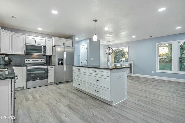 kitchen with tasteful backsplash, visible vents, appliances with stainless steel finishes, light wood-style floors, and white cabinets