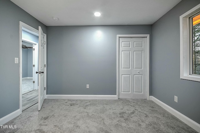 unfurnished bedroom with baseboards and carpet