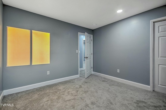 carpeted empty room featuring baseboards