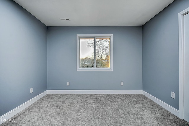 spare room with visible vents, baseboards, and carpet floors