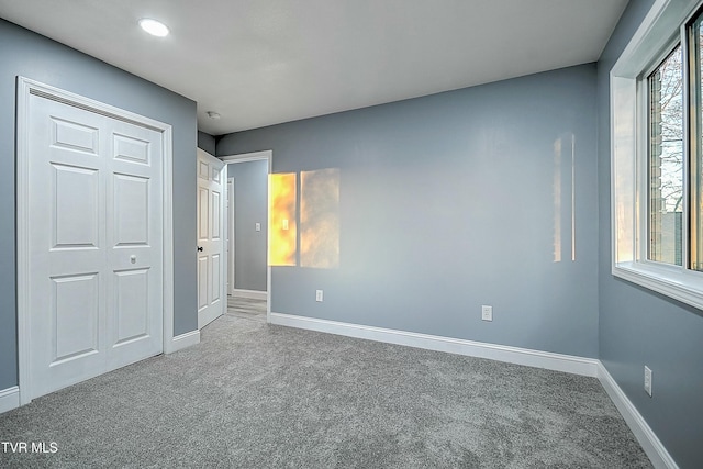 unfurnished bedroom featuring carpet flooring and baseboards