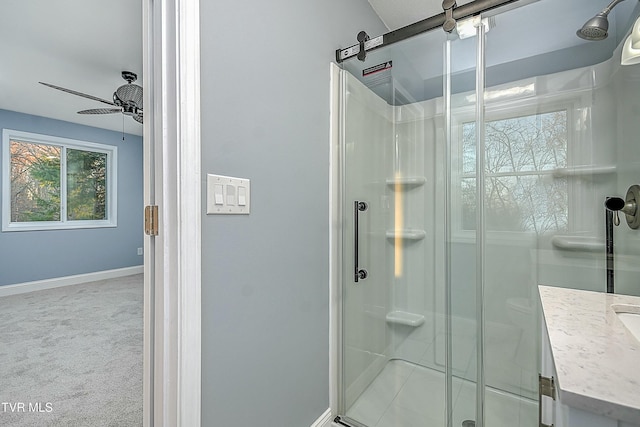 bathroom featuring baseboards, a shower stall, vanity, and a ceiling fan