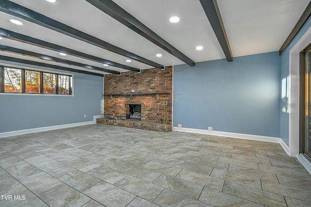 unfurnished living room with beam ceiling, a fireplace, and baseboards