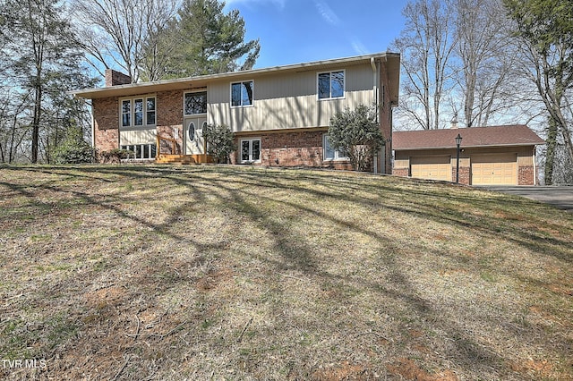 raised ranch with a garage, brick siding, and a chimney