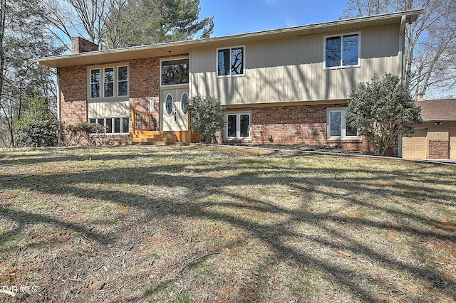 back of property featuring brick siding, a chimney, and a lawn