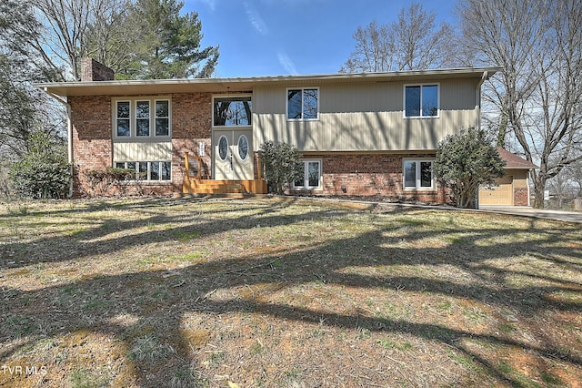 exterior space with brick siding, entry steps, a chimney, and a yard