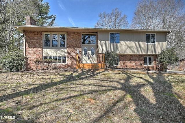 rear view of property with brick siding and a chimney