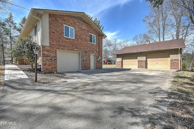 view of side of home featuring an outbuilding and brick siding