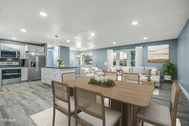 dining area featuring light wood-style flooring, recessed lighting, and baseboards