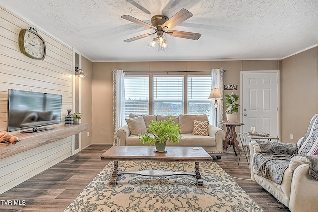 living room featuring dark hardwood / wood-style flooring, a textured ceiling, and ceiling fan