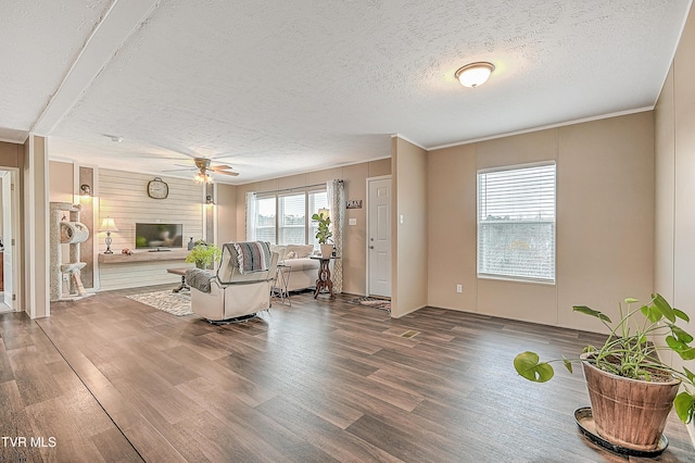 living room featuring ceiling fan, wood-type flooring, a large fireplace, and a textured ceiling