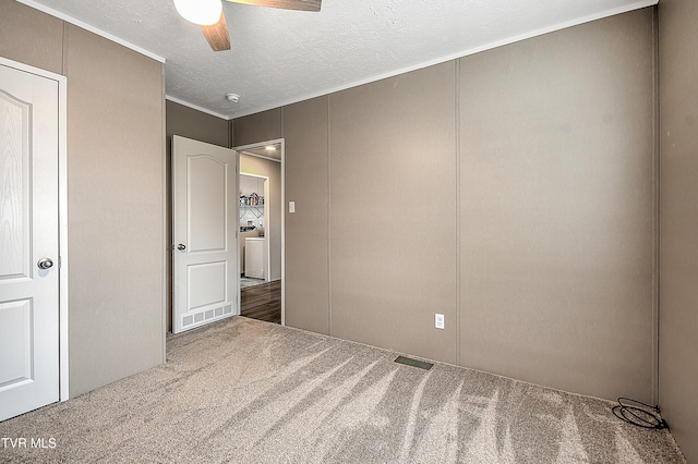 unfurnished bedroom with ceiling fan, ornamental molding, carpet flooring, and a textured ceiling