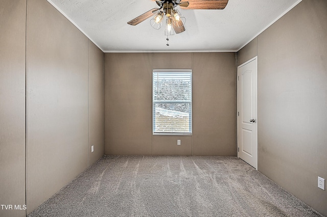 carpeted spare room with crown molding, a textured ceiling, and ceiling fan