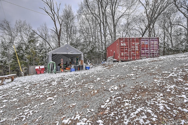 yard layered in snow with an outdoor structure