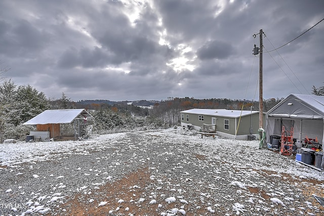 yard covered in snow with a storage shed