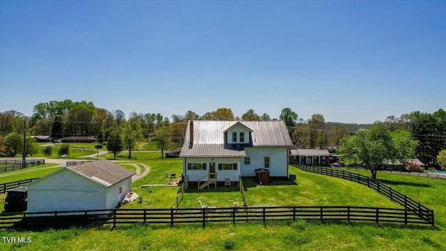 back of house with a rural view