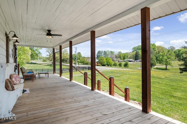 deck with covered porch, a yard, and ceiling fan