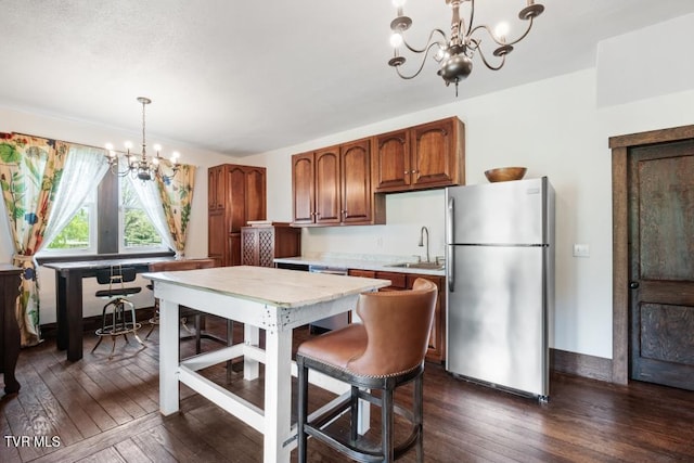 kitchen featuring a chandelier, dark hardwood / wood-style flooring, decorative light fixtures, and stainless steel refrigerator