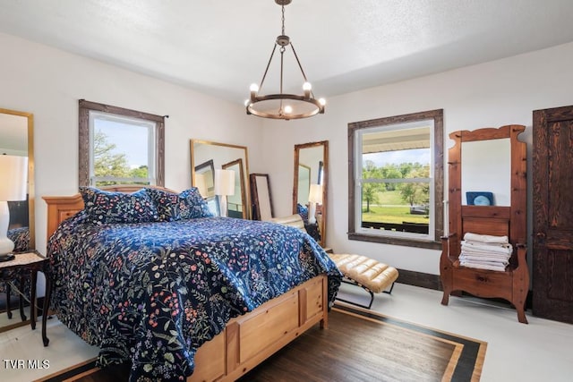 bedroom with a chandelier, dark hardwood / wood-style floors, and multiple windows