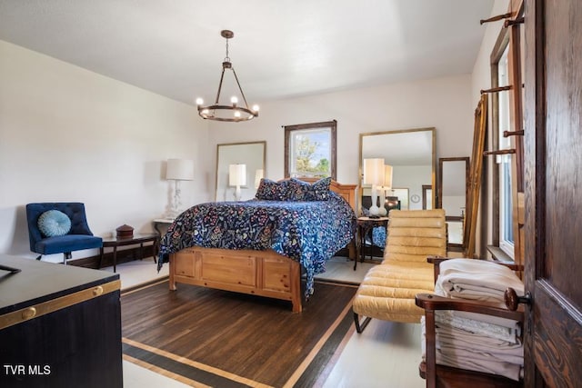 bedroom with dark hardwood / wood-style floors and an inviting chandelier