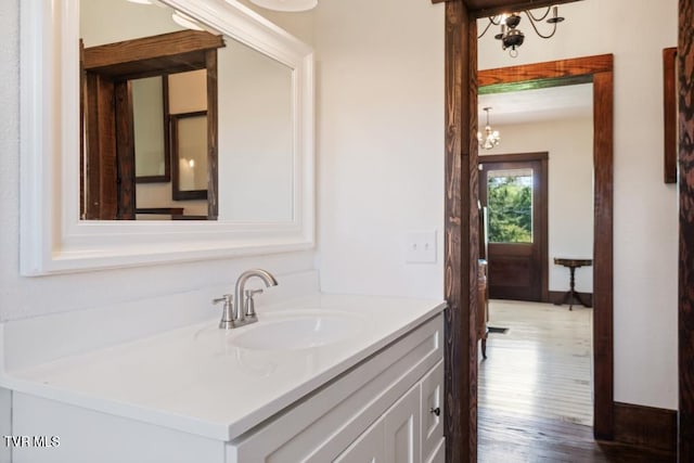 bathroom with hardwood / wood-style floors, vanity, and a notable chandelier