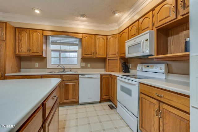 kitchen with white appliances, a sink, and brown cabinets