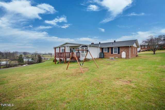 back of house featuring brick siding, a yard, and a wooden deck