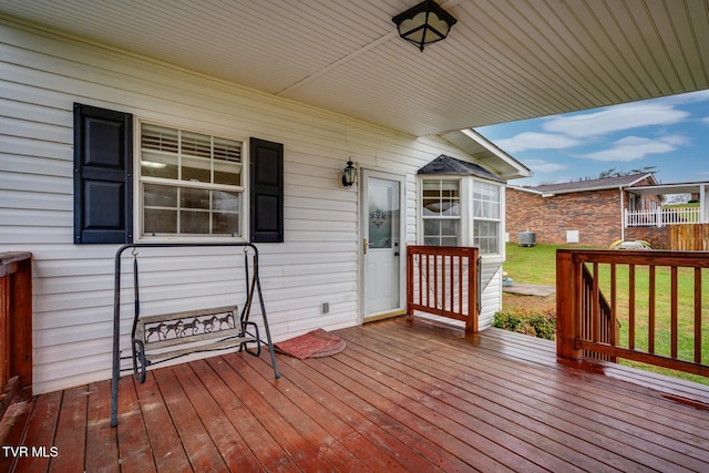 wooden deck featuring a lawn