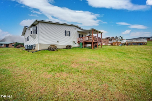 back of house with a deck, central AC, and a lawn