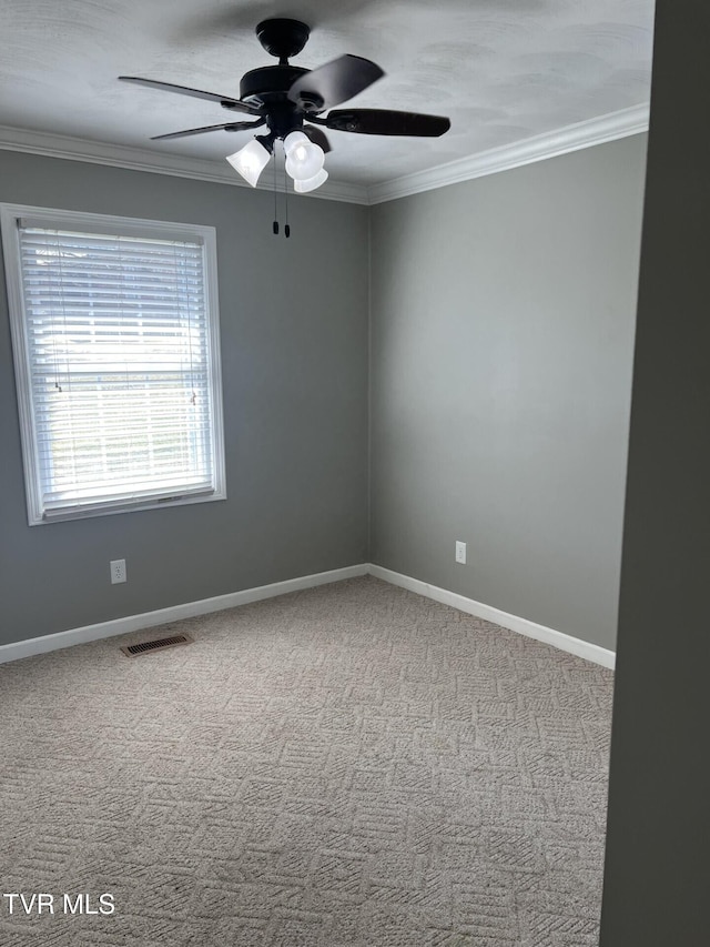 unfurnished room with carpet floors, ornamental molding, and visible vents