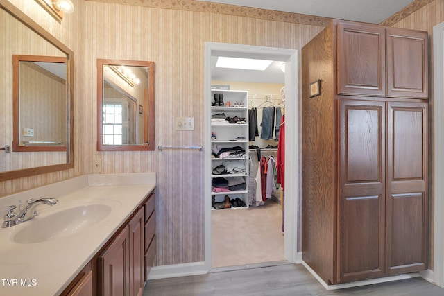 bathroom with vanity, hardwood / wood-style flooring, and wood walls