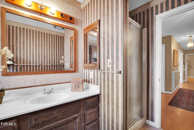 bathroom with a shower with door, vanity, and wood-type flooring