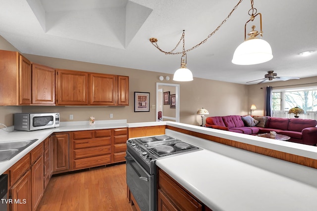 kitchen with ceiling fan, sink, hanging light fixtures, light hardwood / wood-style flooring, and range with electric stovetop