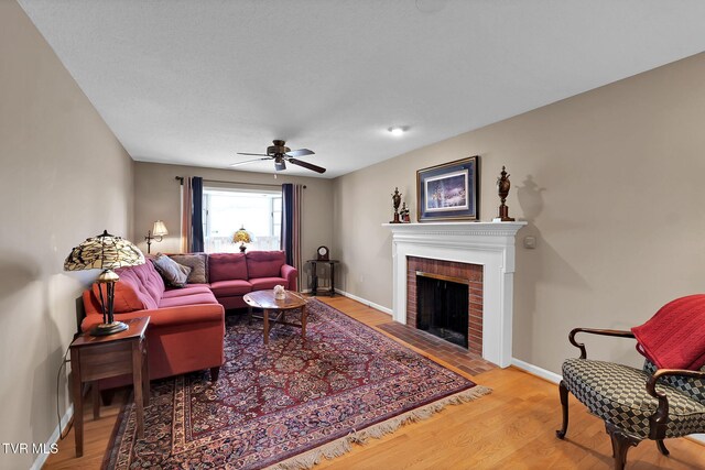 living room featuring a fireplace, ceiling fan, and hardwood / wood-style floors