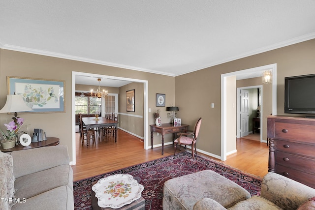 living room with hardwood / wood-style floors, an inviting chandelier, and ornamental molding