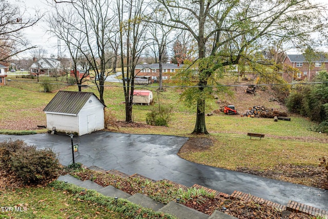 view of property's community with a yard and an outdoor structure